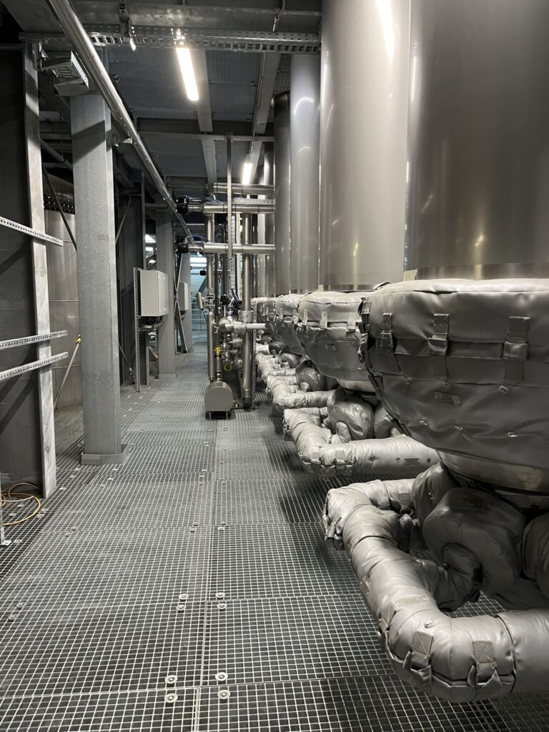 Insulated pipework and equipment along an industrial walkway