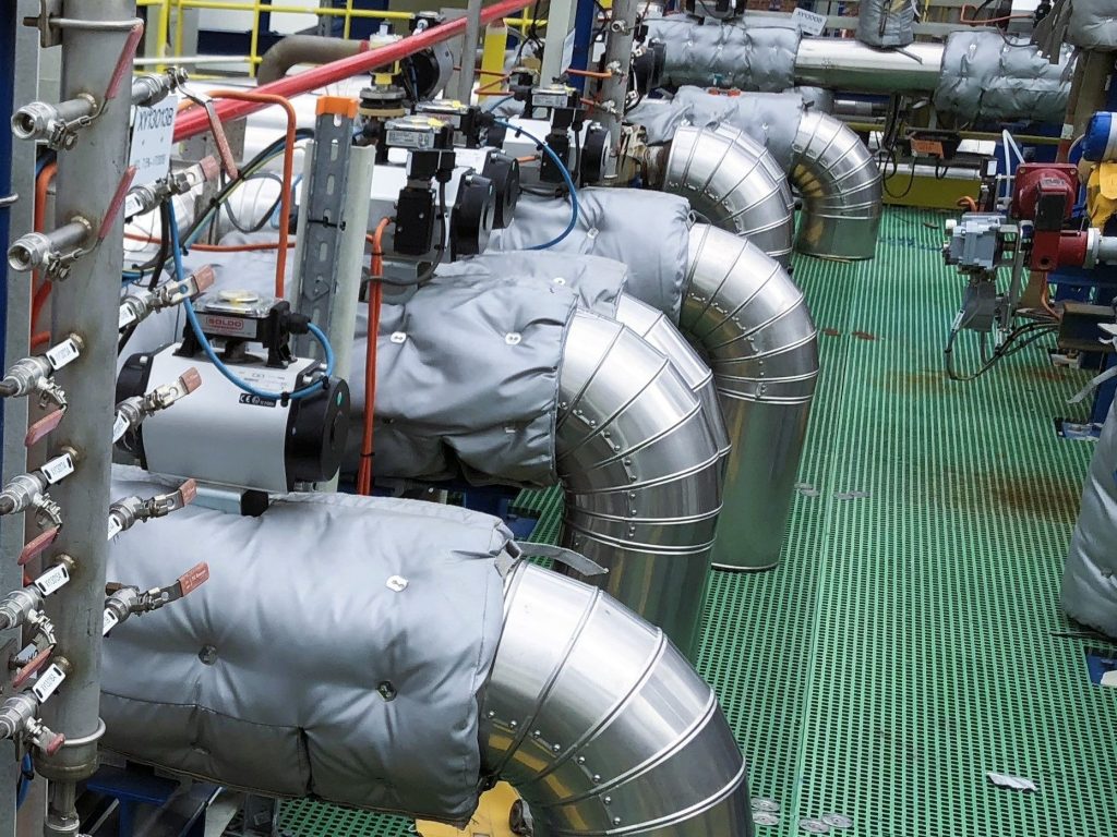 Industrial pipe elbows with metal cladding and fitted insulation mattresses