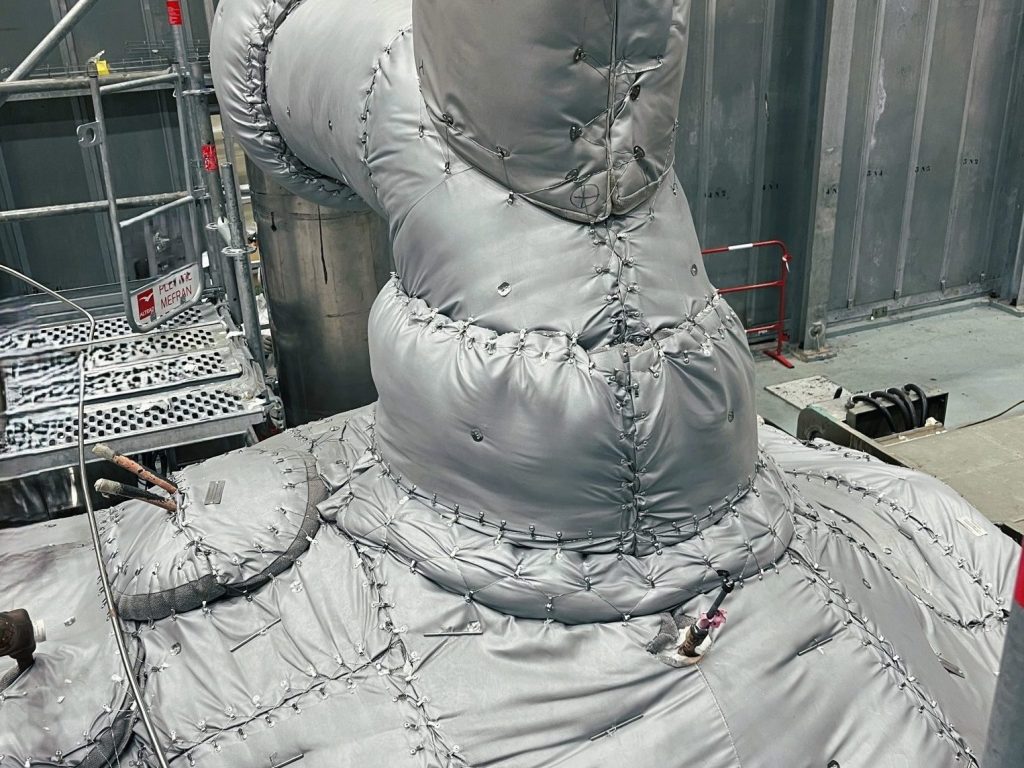 Custom insulation mattresses fitted around a large industrial pipe junction